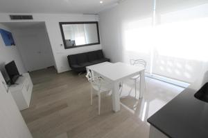 een witte tafel en stoelen in de woonkamer bij For a Stay Roesmar in Cambrils