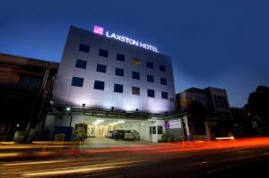 a building with a lit up sign on top of it at Laxston Hotel in Yogyakarta
