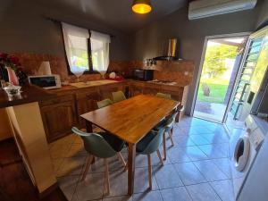 a kitchen with a wooden table and some chairs at VEL'HAUTS RUN in Le Tampon