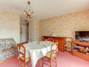 - une salle à manger avec une table, des chaises et une télévision dans l'établissement Apartment l'Etang by Interhome, à Saint-Malo