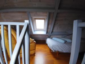 Mały pokój na poddaszu z łóżkiem i oknem w obiekcie Ty Vihan w mieście Plouguerneau