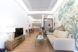 sala de estar con sofá y TV en Arco Macarena Lofts, en Sevilla