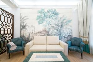 sala de estar con sofá y 2 sillas en Arco Macarena Lofts en Sevilla