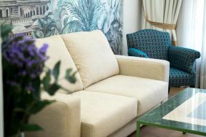 sala de estar con sofá, silla y mesa en Arco Macarena Lofts, en Sevilla