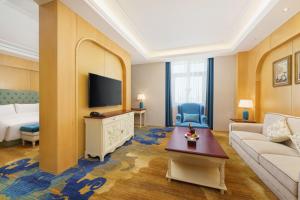 a living room with a couch and a tv at OBOR Hotel in Ürümqi