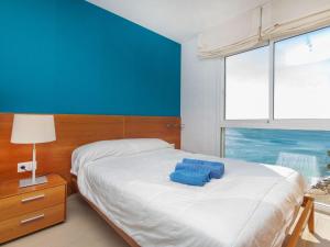 Un dormitorio con una cama con paredes azules y una ventana en Apartment Gala I-3 by Interhome, en Miami Platja