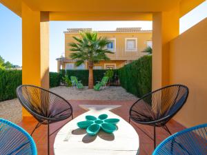a table with three chairs and a green flower on it at Apartment Apartamento Maritimo by Interhome in Benitachell