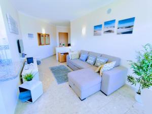 a living room with a couch and a tv at Seaview Apartment Clube Praia Mar in Portimão