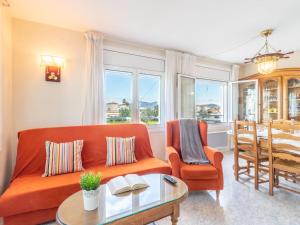a living room with an orange couch and a table at Apartment Sol i Canal by Interhome in Empuriabrava