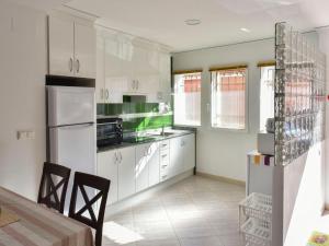 a kitchen with white appliances and a table and chairs at Apartment Caseta Blanqueta by Interhome in Denia