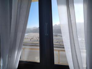 a window with curtains and a view of a highway at Pensión Vega de Pas in Comillas