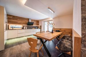 Il comprend une cuisine et une salle à manger avec une table et des chaises en bois. dans l'établissement Chalet Alpendomizil Ahorn, à Mayrhofen