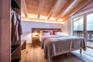 um quarto com uma cama e uma grande janela em Chalet Alpendomizil Ahorn em Mayrhofen