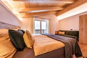 1 dormitorio con 1 cama grande y 1 sofá en Chalet Alpendomizil Ahorn, en Mayrhofen