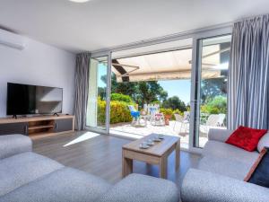 a living room with a couch and a tv at Apartment Cap Roig by Interhome in el Mas Vila