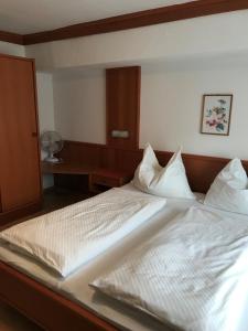 ein großes Bett mit zwei weißen Kissen darauf in der Unterkunft Gästehaus & Weingut Klein in Illmitz