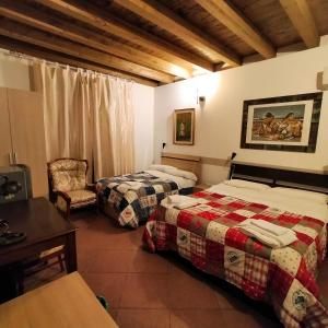 una habitación de hotel con 2 camas y una silla en Terra del Sole Vittoria en Vittoria