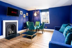 - un salon bleu avec un canapé et des chaises dans l'établissement Darcys' Pride, à Bath