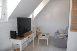 sala de estar con TV y sofá en LE SEUIL en Chartres