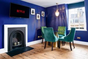 Cette chambre bleue comprend une table, des chaises et une cheminée. dans l'établissement Darcys' Pride, à Bath