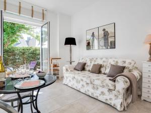 a living room with a couch and a table at Apartment L'Abeille d'Or by Interhome in Carnac