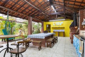 eine Terrasse mit einem Tisch und Stühlen sowie eine Küche in der Unterkunft Casa ampla c/ piscina e churrasqueira em Guararema in Guararema