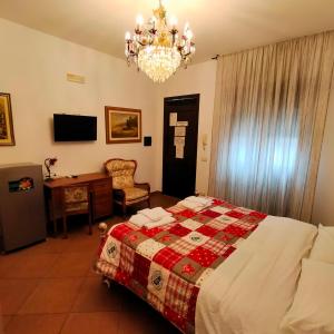 Terra del Sole Vittoria في فيتوريا: غرفة نوم بسرير وثريا