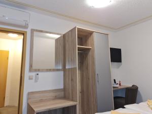 Zimmer mit einem Holzschrank an der Wand in der Unterkunft Landgasthof Sonneneck in Listerfehrda