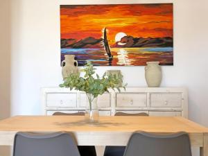 una mesa de comedor con una pintura en la pared en Global Properties, Bonito apartamento en la playa de Corinto, Sagunto, en Sagunto