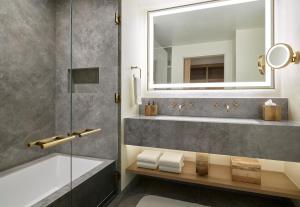 a bathroom with a tub and a sink and a mirror at Limelight Hotel Aspen in Aspen