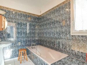 ein Badezimmer mit einer Badewanne, einem Waschbecken und einem Stuhl in der Unterkunft Holiday Home Grah Moullac by Interhome in Carnac