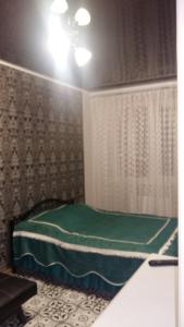 um quarto com uma cama verde num quarto em Морской бриз em Odessa