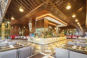 OBOR Hotel في أورومكي: مطعم بطاولات وكراسي وبار