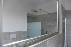 a shower with a mirror in a bathroom at Coco Places Rooms Santa Maria Novella, Centro Storico in Florence
