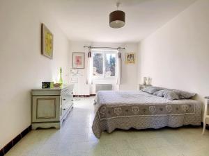 een slaapkamer met een bed, een dressoir en een raam bij Mas Jeannot 8 personnes in Noves