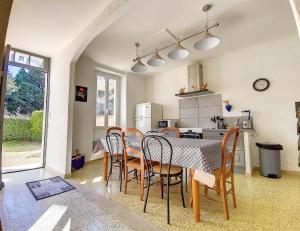 een keuken en eetkamer met een tafel en stoelen bij Mas Jeannot 8 personnes in Noves