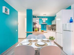 a kitchen with a table and chairs and a blue wall at Apartment Gran Reserva-31 by Interhome in Empuriabrava +14 photos
