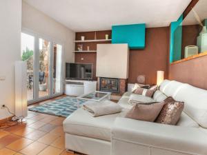 a living room with a white couch and a fireplace at Holiday Home Berganti by Interhome in Tossa de Mar