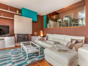 a living room with a white couch and a fireplace at Holiday Home Berganti by Interhome in Tossa de Mar +19 photos