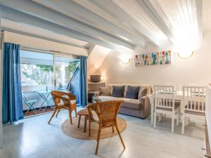 a living room with a couch and a table and chairs at Apartment Les Pins-3 by Interhome in Carnac