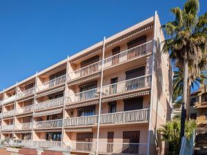 an apartment building with palm trees in front of it at Apartment Les Pins Dorés-2 by Interhome in Sainte-Maxime