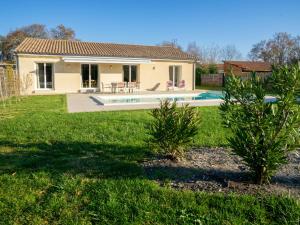 a house with a swimming pool in a yard at Holiday Home Philibert by Interhome in Carcans