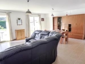 uma sala de estar com um sofá azul e uma cozinha em Holiday Home Philibert by Interhome em Carcans