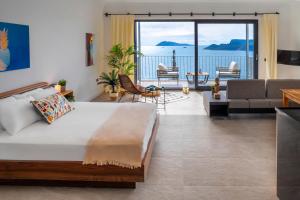 a bedroom with a large bed and a living room at Born in Blue in Kaş
