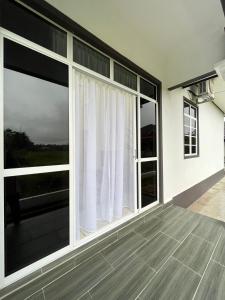 an empty house with large windows and a balcony at Sofea's Homestay in Kuala Terengganu