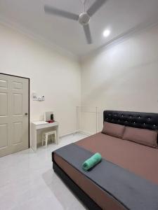 a bedroom with a large bed and a desk at Sofea's Homestay in Kuala Terengganu