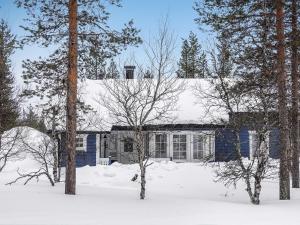 uma casa azul na neve com árvores em Holiday Home Sininen maja by Interhome em Saariselka