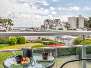 un tavolo con due tazze di caffè e pasticcini su un balcone di Apartment La Cormorane-5 by Interhome a Carnac