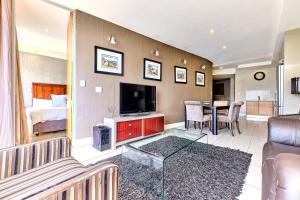 a living room with a couch and a television at Comfort Apartment SA in Johannesburg