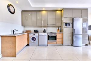 a kitchen with stainless steel appliances and a clock on the wall at Comfort Apartment SA in Johannesburg